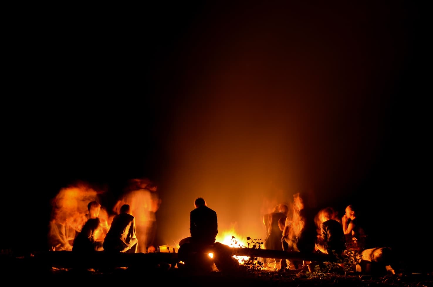 friends are gathered around a campfire